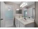 Bathroom with double sinks and vanity, large mirror, and doorway to a bedroom at 309 Oakwood Ct, Lake Mary, FL 32746