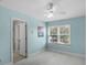 Bright bedroom with a ceiling fan, blue walls, a window, and an access door to the ensuite at 309 Oakwood Ct, Lake Mary, FL 32746