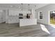 Modern kitchen features white cabinets, gray countertops, stainless steel appliances and an island with pendant lighting at 325 Marion Oaks Golf Way, Ocala, FL 34473