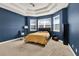 Bedroom with a tray ceiling, three large windows for natural light, and neutral carpet at 332 Terracotta Ter, Howey In The Hills, FL 34737