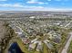An aerial view displays a community with diverse homes, ponds, and lush greenery under a blue sky at 3773 Moon Dancer Pl, St Cloud, FL 34772