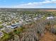 An aerial view of a quiet neighborhood surrounded by trees and a pond under a blue sky at 3773 Moon Dancer Pl, St Cloud, FL 34772