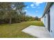 Large grassy backyard with a concrete patio area overlooks lush landscaping and green foliage at 3773 Moon Dancer Pl, St Cloud, FL 34772
