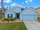 Charming one-story blue home with a well-manicured lawn and a two-car garage at 3773 Moon Dancer Pl, St Cloud, FL 34772