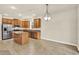 Open-concept kitchen with stainless steel appliances, island, and adjacent dining area at 3773 Moon Dancer Pl, St Cloud, FL 34772