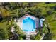 Overhead view of a community pool with chairs, covered patio, and lush landscaping at 3773 Moon Dancer Pl, St Cloud, FL 34772