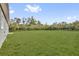 Large grassy backyard surrounded by mature trees and landscaping at 42 Fisher Way Trak, Ocklawaha, FL 32179