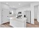 Bright kitchen features white cabinets, modern appliances, and a large center island at 42 Fisher Way Trak, Ocklawaha, FL 32179