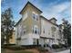 Tan and beige 3 story townhome with dark brown accents and lush landscaping at 4401 Messina Dr, Lake Mary, FL 32746