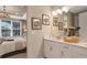Bathroom with double vanity, view into bedroom, and a sleek design at 5702 Gingham Dr, Kissimmee, FL 34758