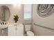 Small bathroom with toilet, sink, and grab bars at 5702 Gingham Dr, Kissimmee, FL 34758
