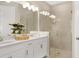 Elegant bathroom with double vanity, quartz countertop, and a glass shower at 5702 Gingham Dr, Kissimmee, FL 34758