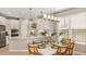 Open concept kitchen with white cabinets, island, and dining area at 5702 Gingham Dr, Kissimmee, FL 34758