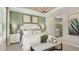 Main bedroom with a king-size bed, green accent wall, and ensuite bathroom at 5702 Gingham Dr, Kissimmee, FL 34758