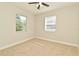 This neutral bedroom features carpet, a ceiling fan and two windows for natural light at 878 Rockhill St, Deltona, FL 32725