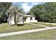 Inviting single-story home featuring a palm tree and well-manicured front lawn at 878 Rockhill St, Deltona, FL 32725
