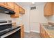 Galley kitchen with stainless steel appliances, wood cabinets, and light countertops at 878 Rockhill St, Deltona, FL 32725