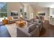 Bright living room with a vaulted ceiling, large windows, and gray sofa seating arrangement at 8920 Fort Jefferson Blvd, Orlando, FL 32822