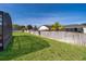 A grassy backyard featuring a wood fence and partial view of screened lanai at 402 Turnstone Way, Orlando, FL 32828