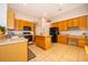 Spacious kitchen with honey colored cabinets and island workstation at 402 Turnstone Way, Orlando, FL 32828