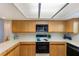 Traditional galley kitchen with white counters, wooden cabinets and a black oven at 1000 Winderley Pl # 122, Maitland, FL 32751