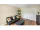 Casual living room area with dark futon couch and shelving, wood floors at 1000 Winderley Pl # 122, Maitland, FL 32751