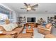 Living room with brown leather couches, a large TV, and built-in shelving at 10897 Sw 80Th Ct, Ocala, FL 34481