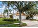 Charming single-story home featuring a two-car garage, brick driveway, and mature landscaping at 11753 Fan Tail Ln, Orlando, FL 32827