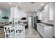 Open kitchen design featuring white cabinetry, stainless steel appliances, and a casual dining area at 11753 Fan Tail Ln, Orlando, FL 32827