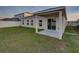 Expansive backyard featuring a covered porch, lush grass, and secure fencing at 1207 Tank Trl, Haines City, FL 33844