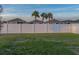 Lush green backyard enclosed by a tall white fence, providing privacy and security at 1207 Tank Trl, Haines City, FL 33844