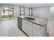 Modern kitchen island with stainless steel dishwasher, granite countertops and view to outdoor living space at 1207 Tank Trl, Haines City, FL 33844