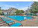 Community pool with lounge chairs and blue umbrellas at 13003 Plantation Park Cir # 1319, Orlando, FL 32821