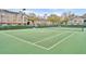 Enjoy a match on the community tennis court with well-maintained green surface and a backdrop of lush landscaping at 13003 Plantation Park Cir # 1319, Orlando, FL 32821