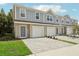 New townhome showcasing a gray exterior, brick paver driveway, and attached garage at 1317 Fan Palm Dr, Davenport, FL 33897