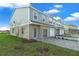 Gray townhome showcasing a landscaped yard and brick paver driveway at 1317 Fan Palm Dr, Davenport, FL 33897