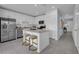 Kitchen featuring island with bar seating, white cabinets, and stainless steel appliances at 1317 Fan Palm Dr, Davenport, FL 33897