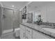 A modern bathroom featuring a walk-in shower, granite countertops, and contemporary fixtures at 1317 Fan Palm Dr, Davenport, FL 33897