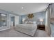 Well-lit main bedroom with serene blue walls, a large bed, and carpeted flooring at 1317 Fan Palm Dr, Davenport, FL 33897