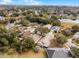 An aerial view of a residential neighborhood with mature trees, well-maintained lawns, and a picturesque lake in the background at 13713 Meadowpark Ave, Orlando, FL 32826