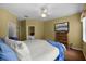 Comfortable bedroom featuring wood floors, a ceiling fan and a dresser with a television at 13713 Meadowpark Ave, Orlando, FL 32826