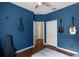 Vibrant blue bedroom with hardwood floors, ceiling fan, and guitars on wall creates music haven at 13713 Meadowpark Ave, Orlando, FL 32826