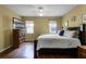 Comfortable bedroom featuring wood floors, a ceiling fan and a dresser with a television at 13713 Meadowpark Ave, Orlando, FL 32826