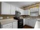 Well-lit kitchen features white cabinets, stainless steel appliances, and tile backsplash at 13713 Meadowpark Ave, Orlando, FL 32826