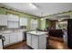 Bright kitchen with white cabinets, stainless steel appliances, an island, and hardwood floors at 13713 Meadowpark Ave, Orlando, FL 32826