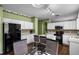 An open kitchen with white cabinets, tile backsplash, kitchen island, and adjacent dining area at 13713 Meadowpark Ave, Orlando, FL 32826