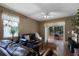 Cozy living room features hardwood floors, a leather sofa, and a sliding glass door leading to the backyard at 13713 Meadowpark Ave, Orlando, FL 32826