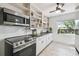 Well-lit kitchen featuring stainless steel appliances, white cabinetry, and a window overlooking the yard at 1412 Nebraska St, Orlando, FL 32803