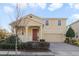 Two-story house with a red door, two-car garage, and landscaped yard at 14502 Bahama Swallow Blvd, Winter Garden, FL 34787