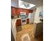 Cozy kitchen with orange cabinets, white appliances, and a ceiling fan at 1500 Gay Rd # 10C, Winter Park, FL 32789